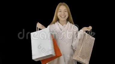 一位带着纸袋的快乐女孩在以<strong>折扣价</strong>购买圣诞商品后的肖像
